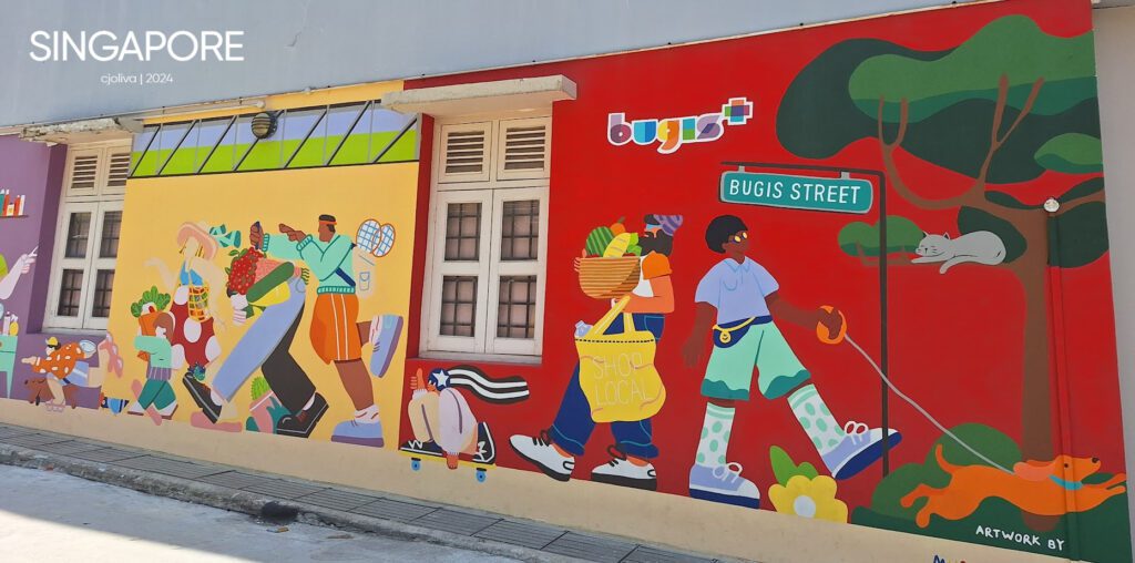 Colorful mural in Singapore’s Bugis Street depicting people shopping, walking dogs, and everyday life with bold colors and playful details.
