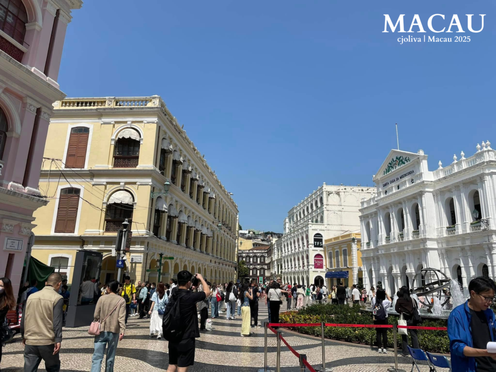 Crowds at Senado Square in Macau with colonial pastel buildings and Santa Casa da Misericórdia landmark.