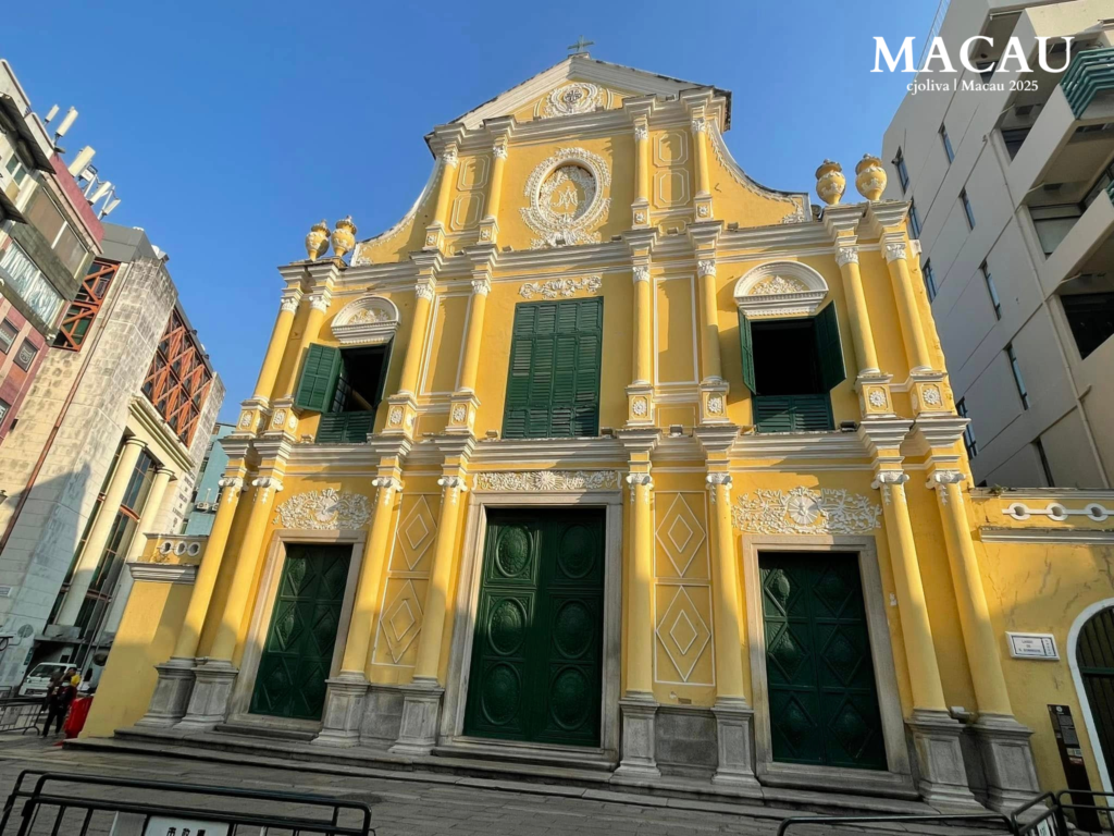 St. Dominic’s Church in Macau with yellow baroque facade, ornate columns, and green shutters.