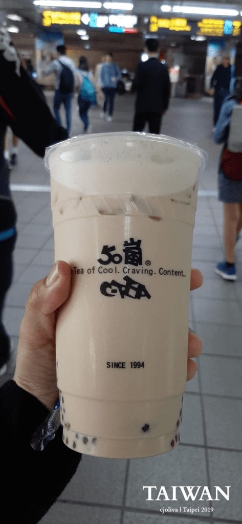 Hand holding 50 Lan bubble teacup in Taipei, Taiwan.