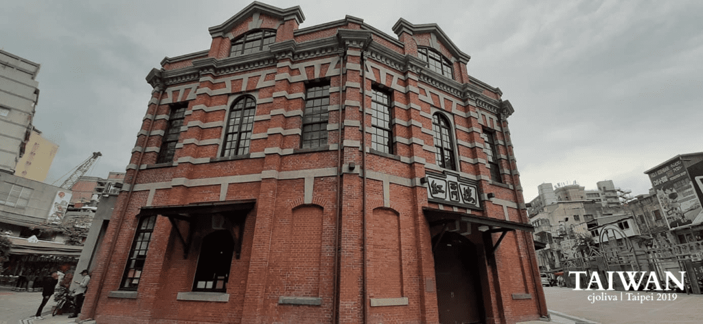 Historic red‑brick building with arched windows and stone accents in Taipei, Taiwan.