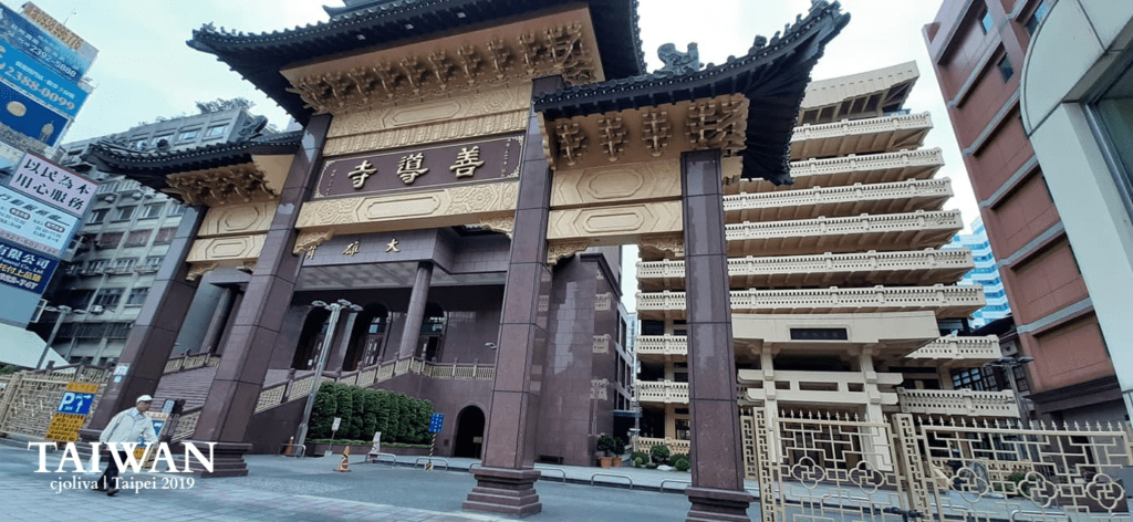 Shandao Temple gate with ornate roof and gold inscriptions in Taipei, Taiwan.