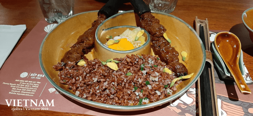 Vietnam Street Food and Culture were showcased in a traditional ceramic bowl with grilled meat skewers, rice garnished with herbs and petals, and pickled vegetables at Bếp Nhà Lục Tỉnh restaurant.