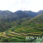 Scenic view of lush green rice terraces on mountain slopes with scattered houses in Buscalan, taken in 2018.