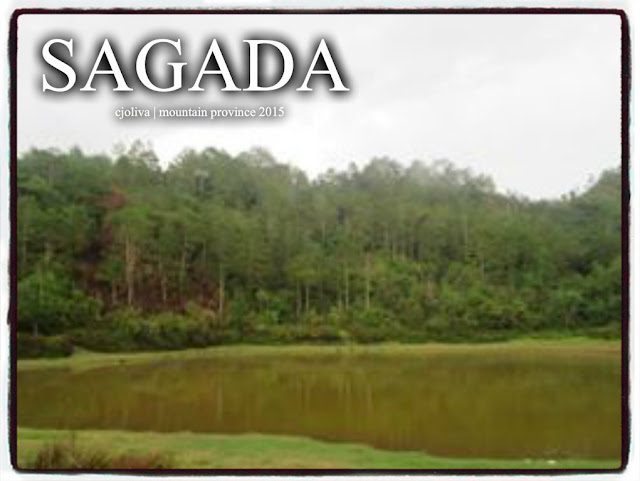 Calm Lake Danum is surrounded by forested hills under an overcast sky in Sagada, Mountain Province, Philippines.