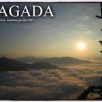 Sunrise casting golden light over cloud-filled valleys and mountain ridges in Sagada, Mountain Province, with a silhouetted tree in the foreground.