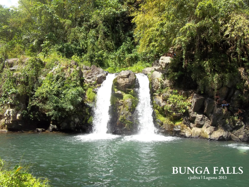 Twin streams of water cascading down rocky cliffs into a clear natural pool surrounded by lush green foliage at Bunga Falls, Laguna, 2013.