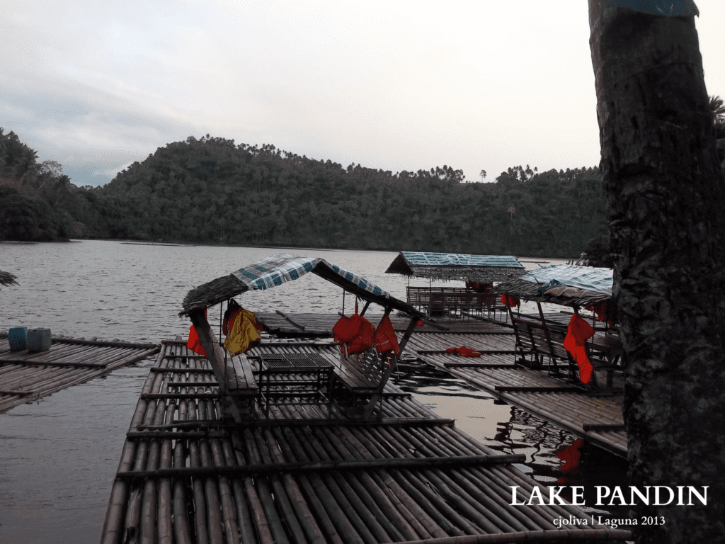 Bamboo rafts with thatched roofs and life jackets floating on Lake Pandin with forested hills in the background, taken in Laguna, 2013.