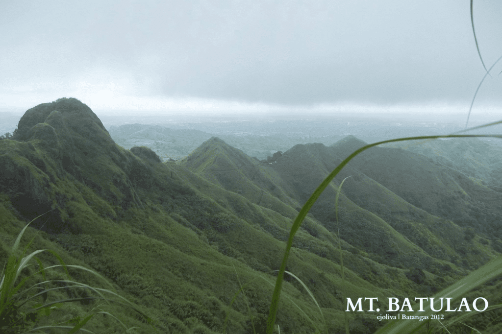 Expansive view of lush green hills and valleys of Mt. Batulao under cloudy sky in Batangas