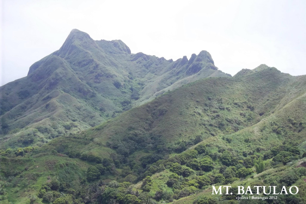 Lush green mountain range of Mt. Batulao under a bright sky in Batangas, Philippines