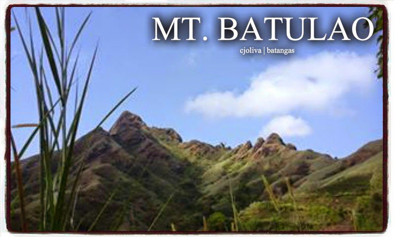 Sharp ridges of Mt. Batulao mountain with blue sky and green grass in the foreground