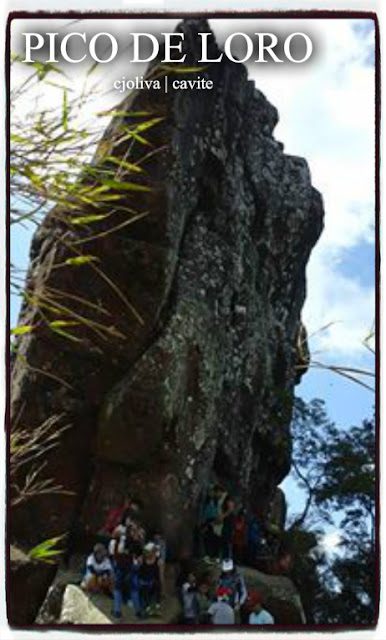 A group of hikers resting at the foot of the massive stone monolith at Mt. Pico de Loro in Cavite.
