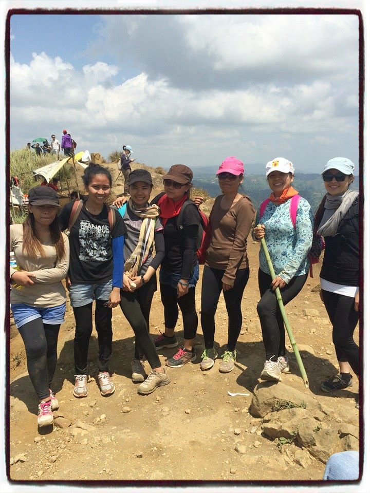 Group of women hikers posing together on the rocky summit of Mt. Batulao under a sunny sky