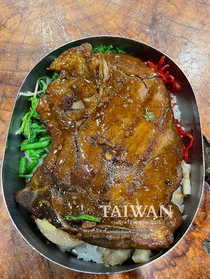Taiwanese bento meal in metal container with glazed pork chop on rice, leafy greens, and shredded red peppers, served in Fenqihu, Chiayi