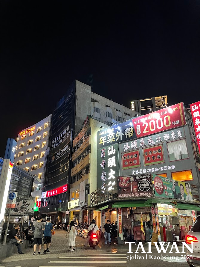 Night street scene in Kaohsiung, Taiwan, with neon signs and city lights