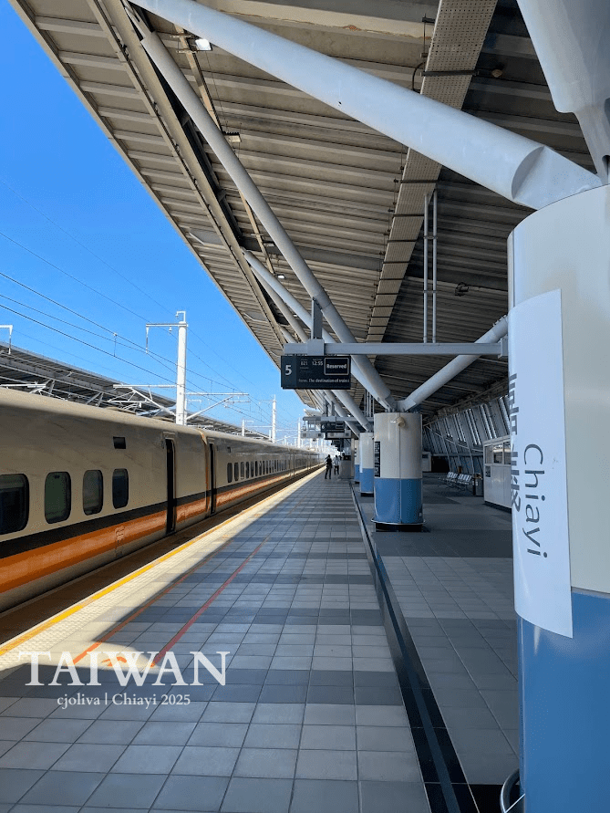 Modern train station in Chiayi, Taiwan with sleek high-speed train on platform 5 under angular roof and white beams