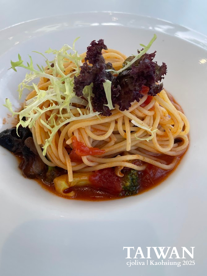 Close-up of a plated pasta dish with fresh greens in a minimalist white ceramic bowl, Kaohsiung, Taiwan.
