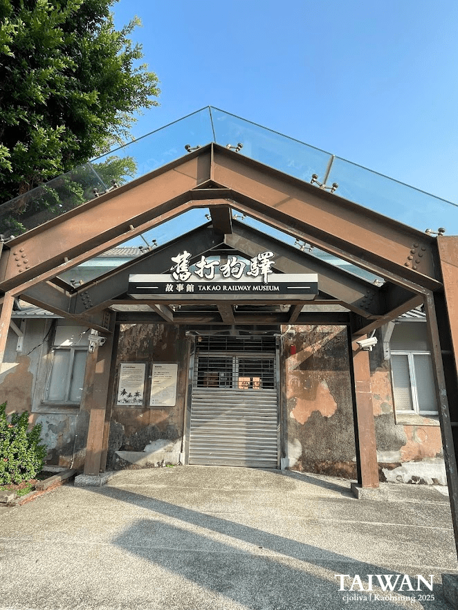 Entrance to the Takao Railway Museum in Kaohsiung, Taiwan, with a glass roof, signage in Chinese and English, and a weathered building facade.
