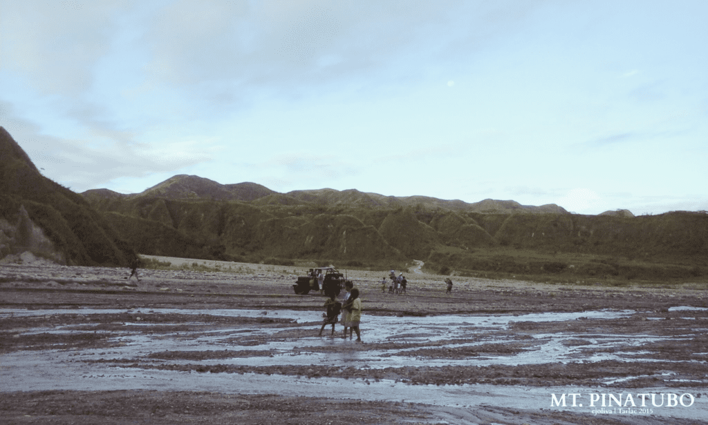 A 4x4 off-road vehicle navigating the shallow river streams and rocky lahar landscape of Mt. Pinatubo.