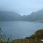 Misty view of the crater lake at Mt. Pinatubo surrounded by steep rocky slopes and vegetation in Tarlac, 2015.