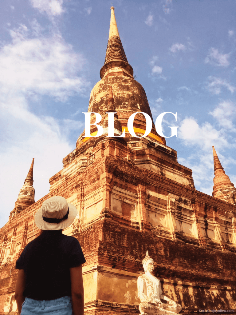 Traveler in straw hat standing before ancient Buddhist temple with red brick stupa and seated Buddha statue