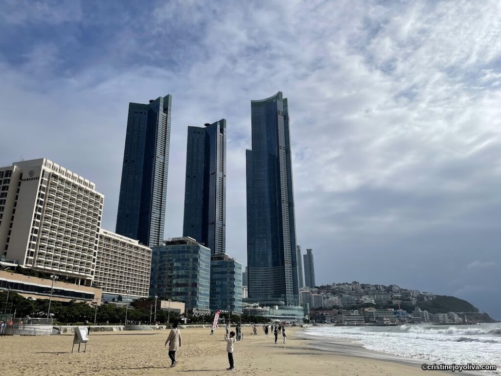 Busan coastal cityscape with Paradise Hotel, skyscrapers, and beach shoreline