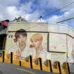 Busan mural of Jungkook and Jimin holding roses near souvenir shop