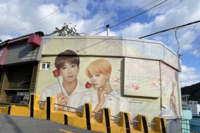 Busan mural of Jungkook and Jimin holding roses near souvenir shop