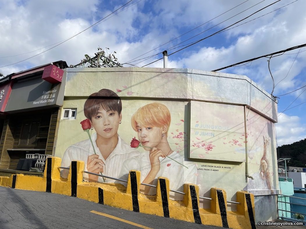 Busan mural of Jungkook and Jimin holding roses near souvenir shop