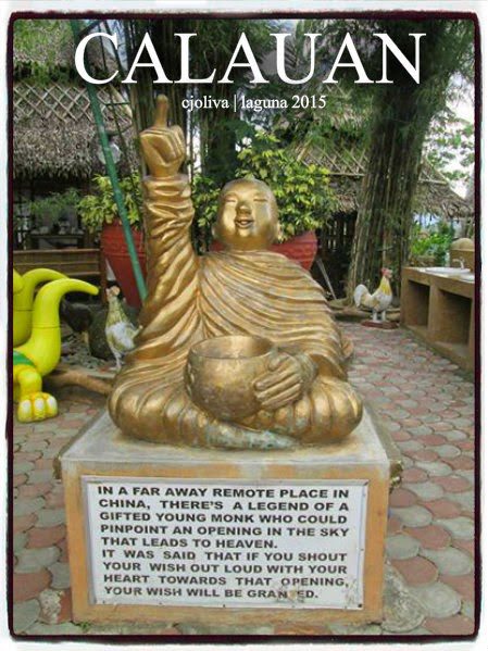 Golden monk statue with raised arm and bowl on pedestal surrounded by trees at Calauan cultural site in Laguna, Philippines