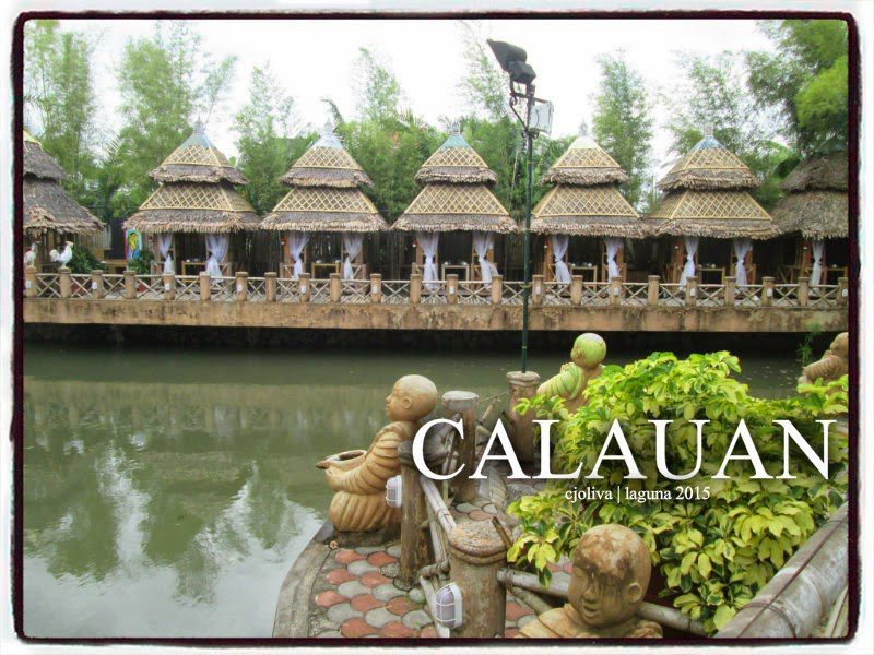 A row of nipa hut cottages with white curtains along a calm river in Calauan, Laguna, Philippines