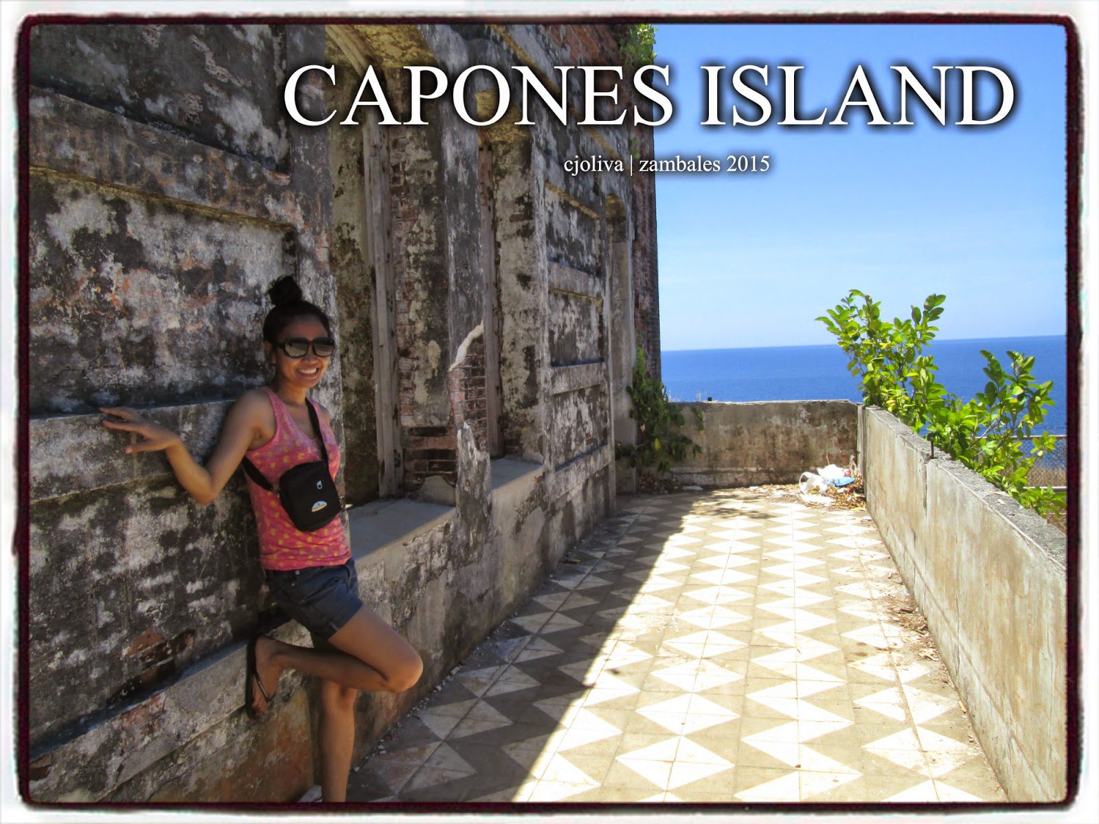 A woman leaning against the weathered stone walls of the Capones Island lighthouse balcony, showing checkered floor tiles and a view of the blue ocean.