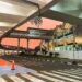 Soekarno–Hatta International Airport skybridge in Jakarta at sunset, with modern glass architecture, clean road markings, and a vivid orange-pink sky.