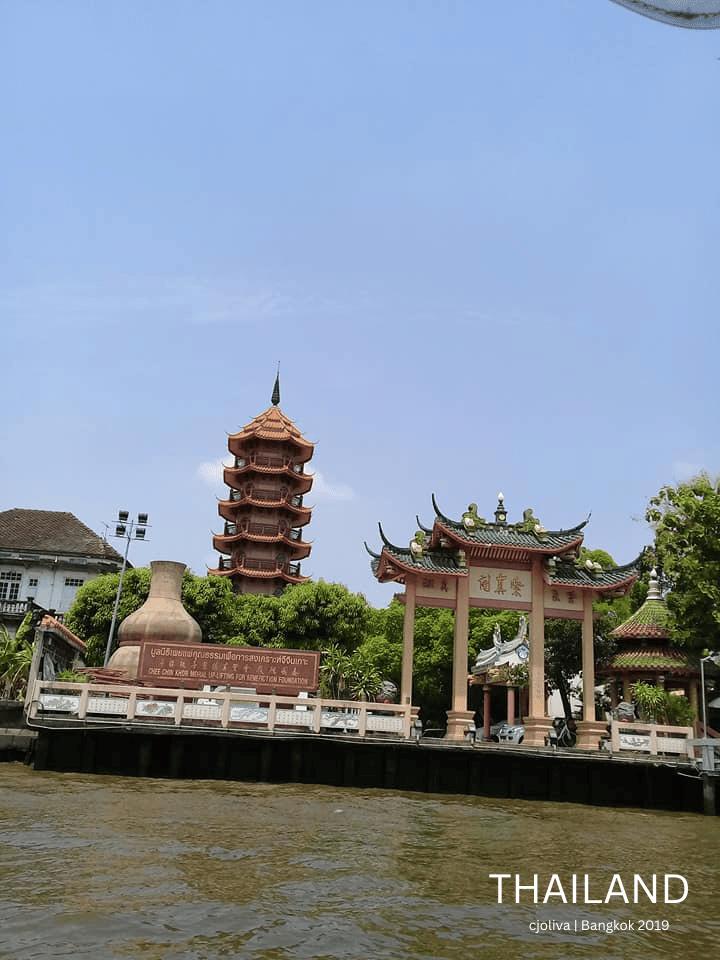 A view from the water of the orange Chee Chin Khor pagoda and a Chinese-style gateway on the banks of the Chao Phraya River in Bangkok.