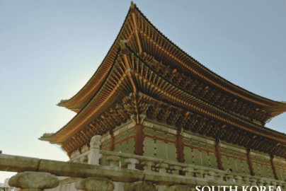 Gyeongbokgung Palace traditional Korean architecture with intricate green and red woodwork under a clear sky in Seoul.