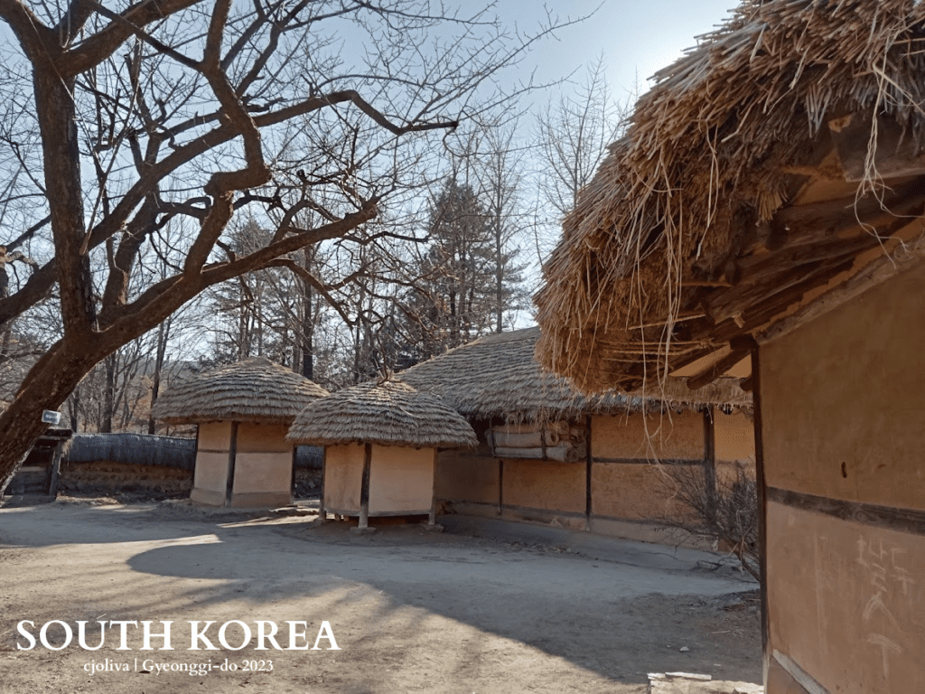 Cluster of traditional Korean thatched-roof houses with clay walls and wooden beams at Korean Folk Village in Gyeonggi-do, South Korea, 2023