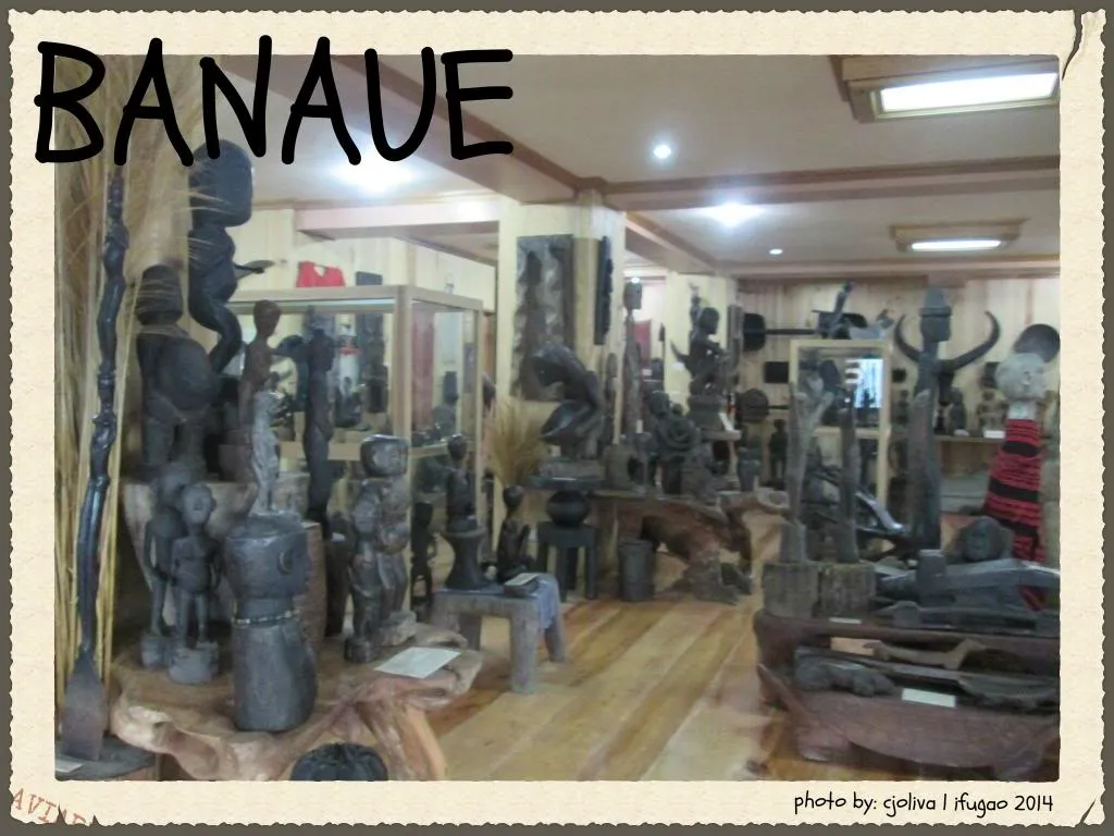 An indoor display of various traditional Ifugao wood carvings, including Bulul statues and cultural artifacts, on wooden stands in a museum in Banaue.