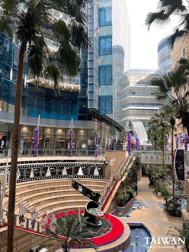 Dream Mall plaza in Kaohsiung, Taiwan with glass commercial complex, amphitheater, film reel sculpture, and festive decorations