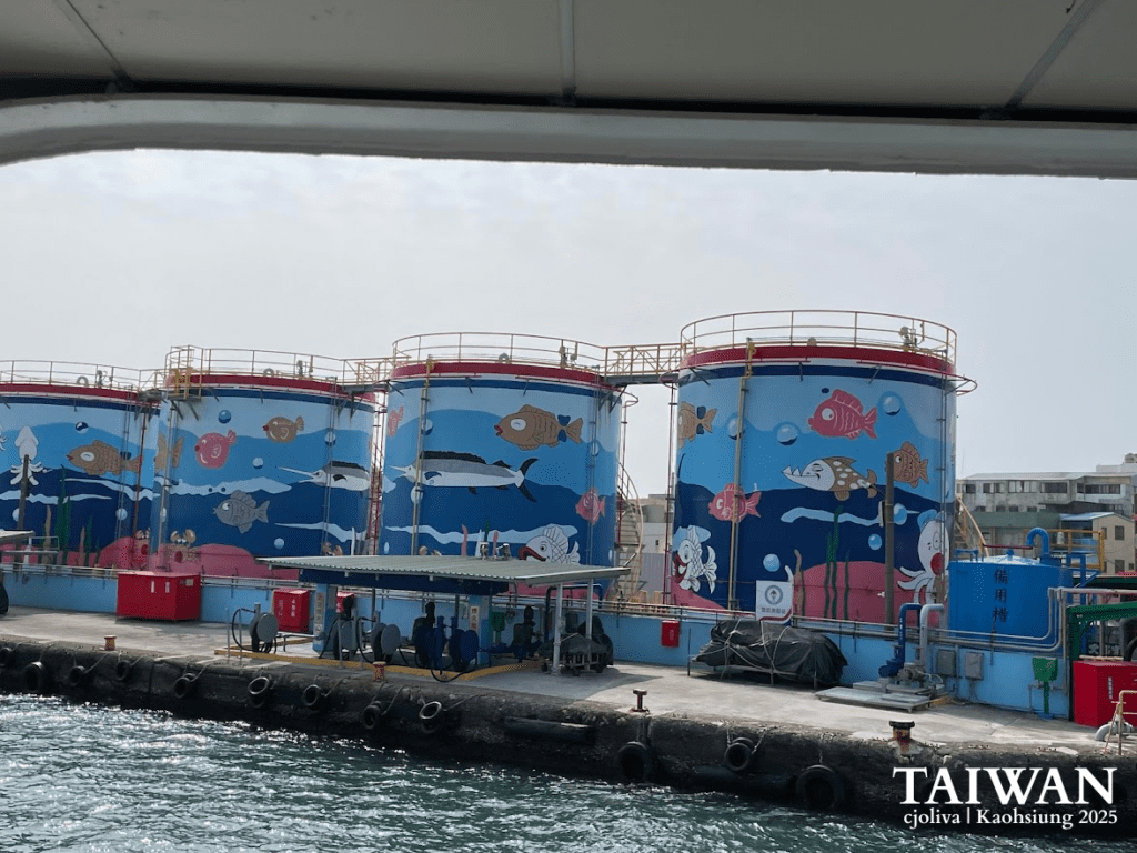 Cylindrical storage tanks painted with colorful underwater murals of fish, squid, and seaweed at Kaohsiung harbor in Taiwan