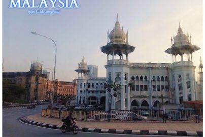 Historical Indo-Saracenic building in Kuala Lumpur, Malaysia, with ornate domes, arched windows, and decorative columns, set against modern city buildings
