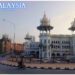 Historical Indo-Saracenic building in Kuala Lumpur, Malaysia, with ornate domes, arched windows, and decorative columns, set against modern city buildings