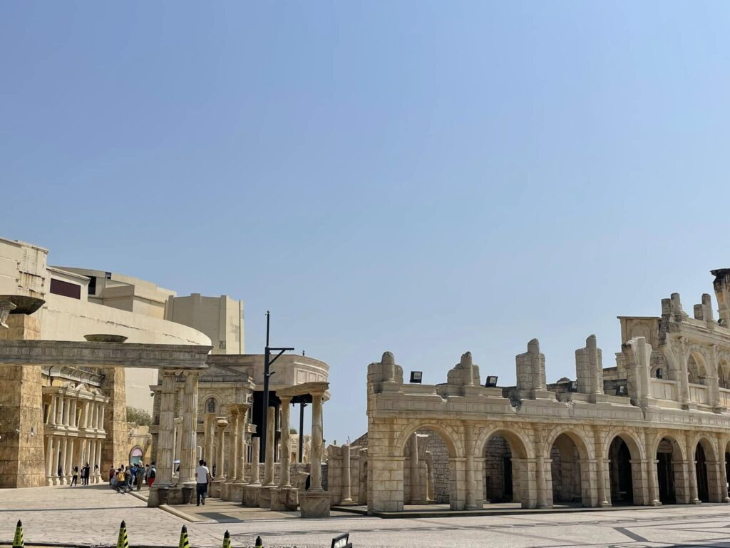 Solo travel Asia: Classical Roman-style stone arches and columns at Macau Fisherman's Wharf under a clear blue sky.