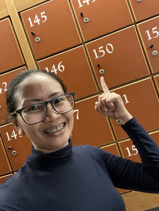 Person pointing at orange locker number 150 at National Chung Cheng University in Chiayi, Taiwan, featured in Meteor Garden