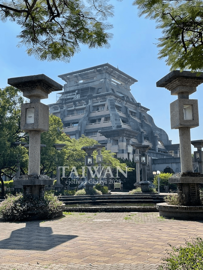 Modern angular building at National Chung Cheng University in Chiayi, Taiwan with stone lanterns, landscaped trees, and paved walkways