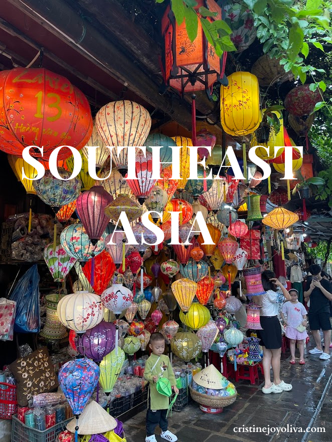 Colorful lanterns at a bustling Southeast Asia street market, with vibrant reds, yellows, purples, and blues creating a festive atmosphere