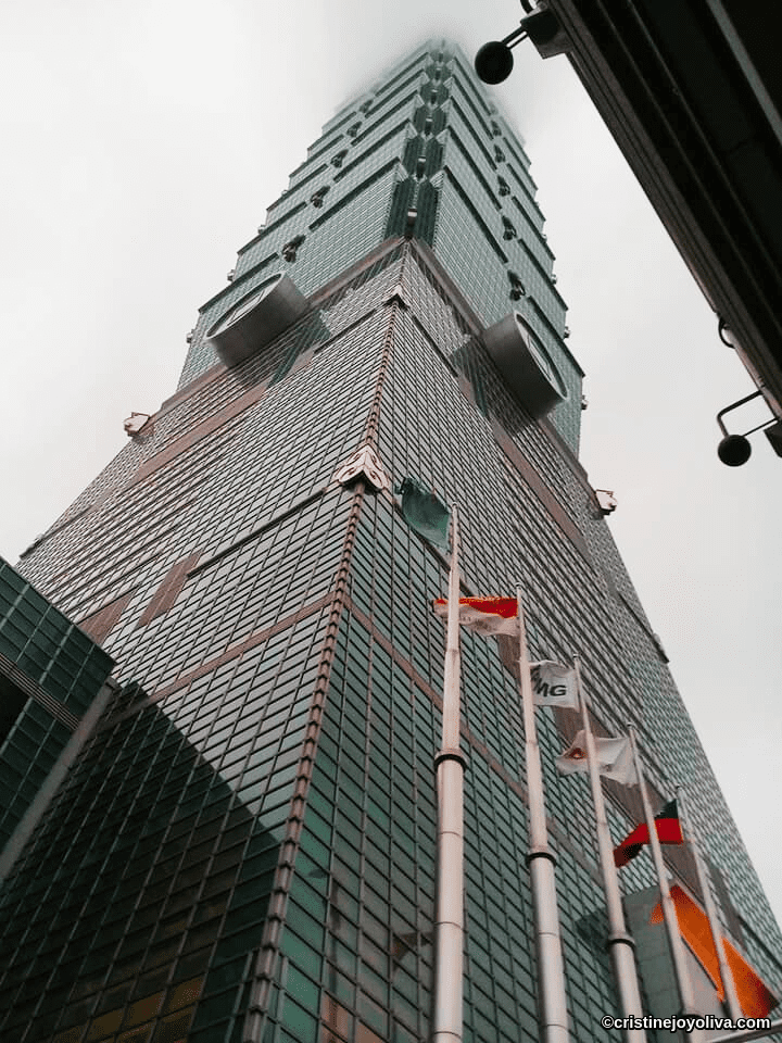 Taipei 101 skyscraper in Taiwan with tiered design and glass facade disappearing into clouds in 2019