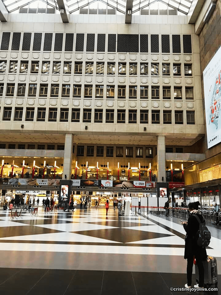Taipei Main Station interior with geometric glass roof, tiled floor, and travelers in 2019