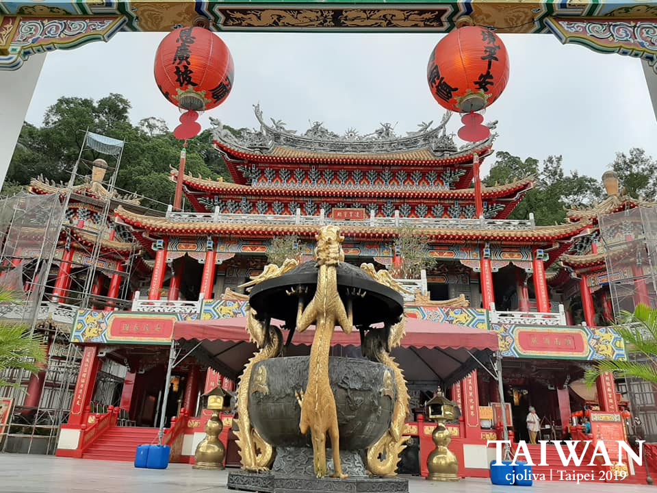 Traditional temple in Taipei with ornate roofs, red lanterns, and dragon incense burner