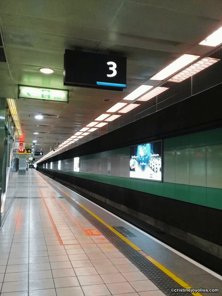 Taoyuan High-Speed Rail station platform in Taiwan with tiled flooring, exit signs, and digital screens in 2019
