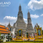 The white porcelain prangs of Wat Arun temple against a blue sky in Bangkok.